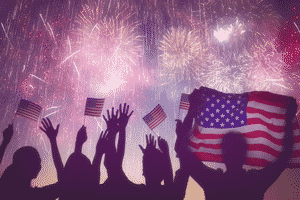 fireworks with silhouetted people and American flags